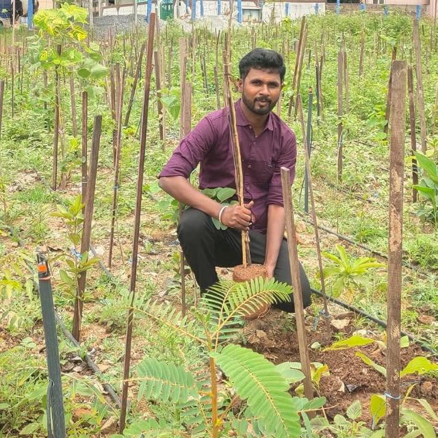 Senthil — Founder, Karisakattu Poove Trust, planting a sapling